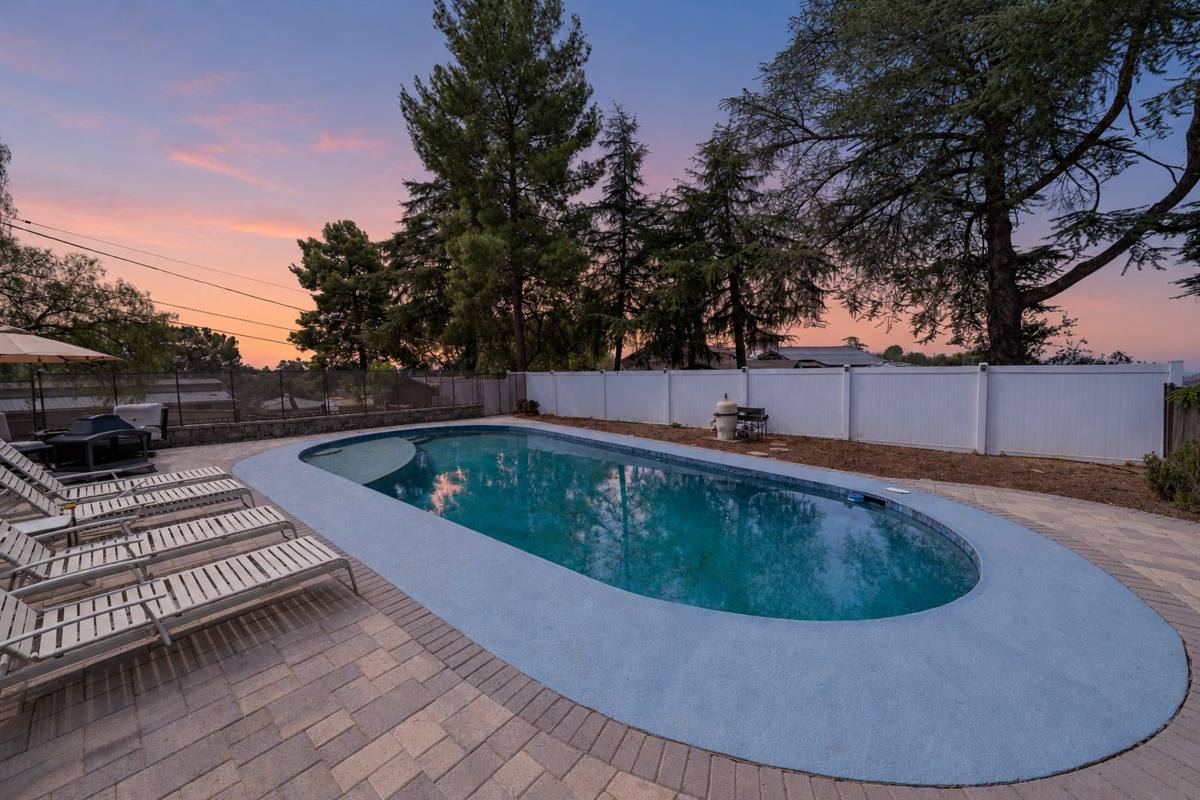 Private pool with paver deck and lounge chairs at dusk