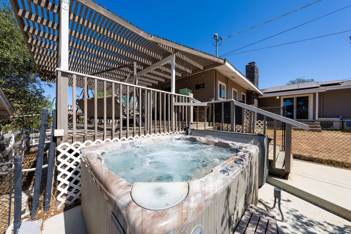 Spa beside the pergola-covered deck off the back of the home