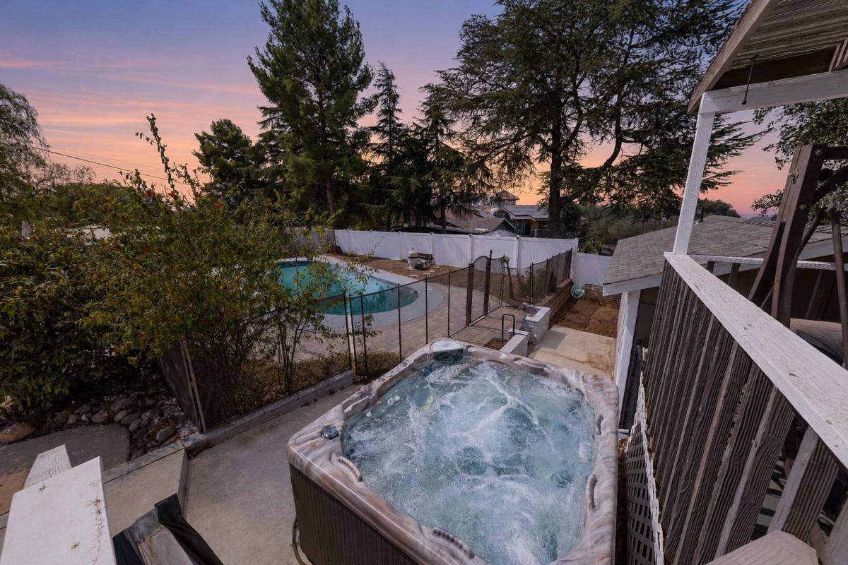 Spa overlooking the fenced pool at twilight